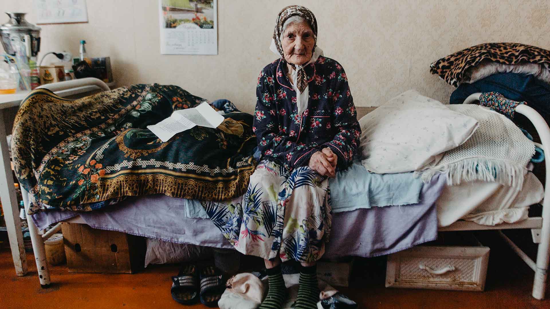 An elderly lady sat on her bed, Ukraine