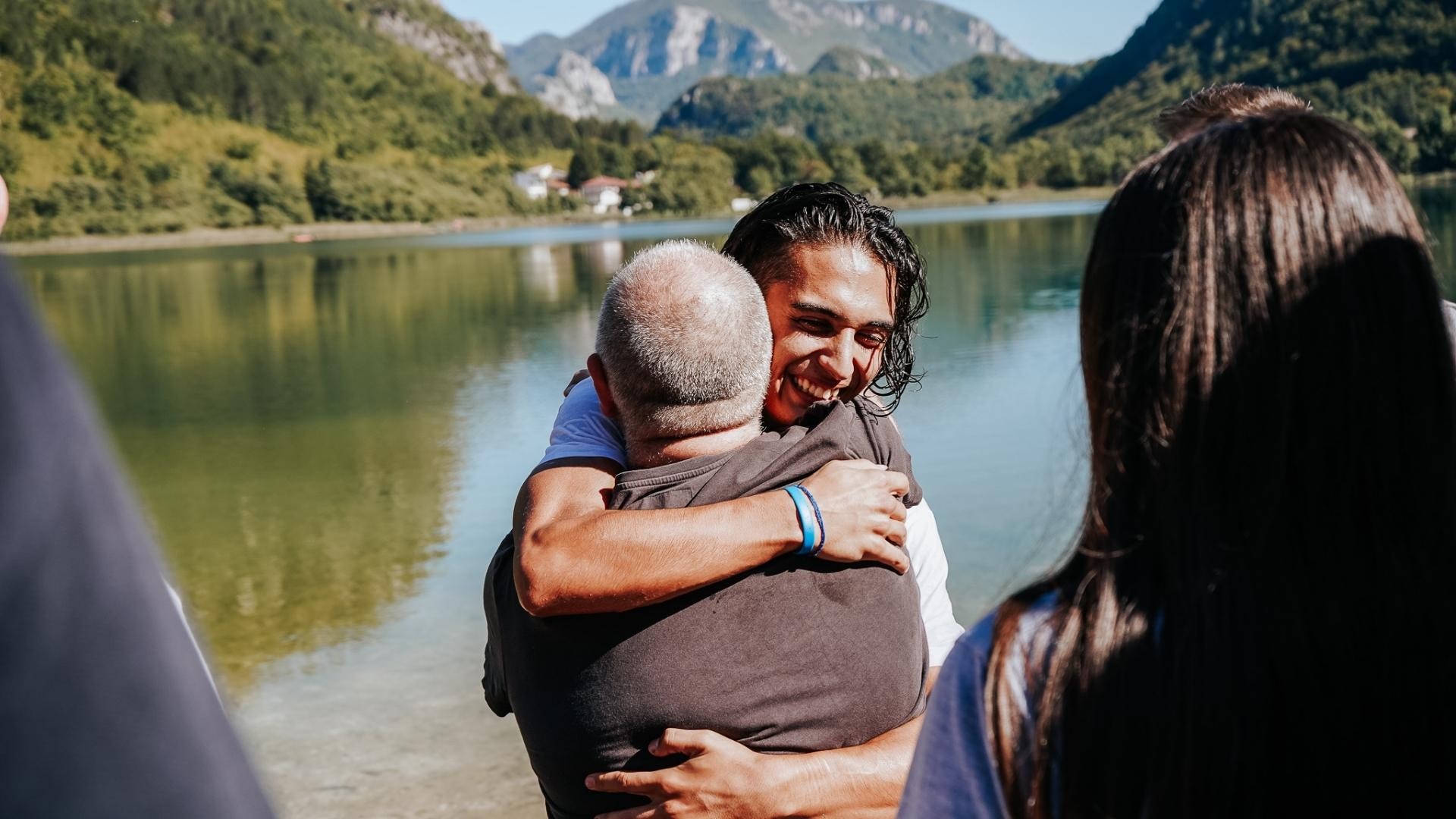 Young man and elderly man sharing a joyful embrace.