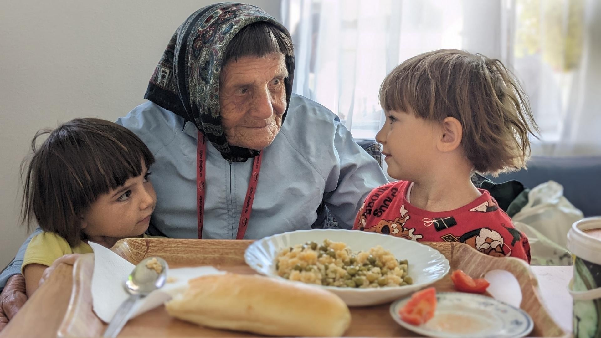 Elderly woman engaging with two small children