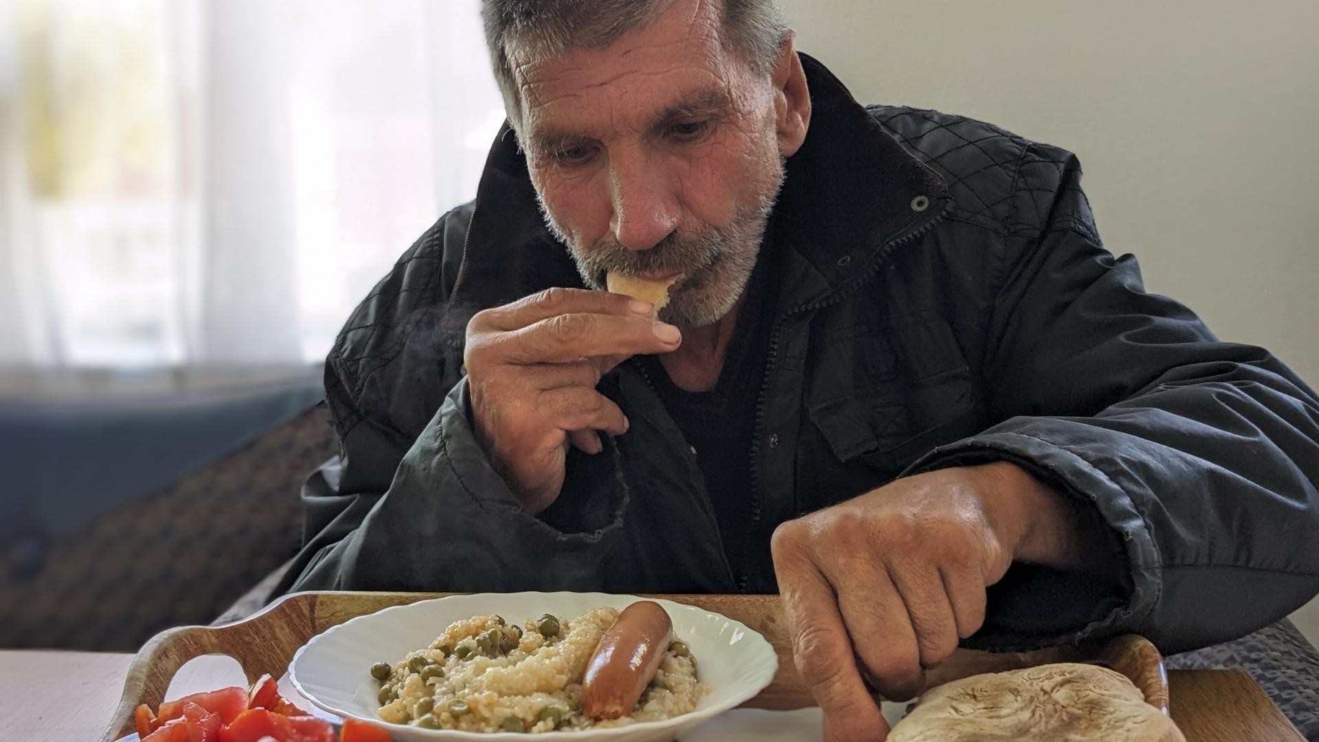 Man with short beard eating a hot meal.