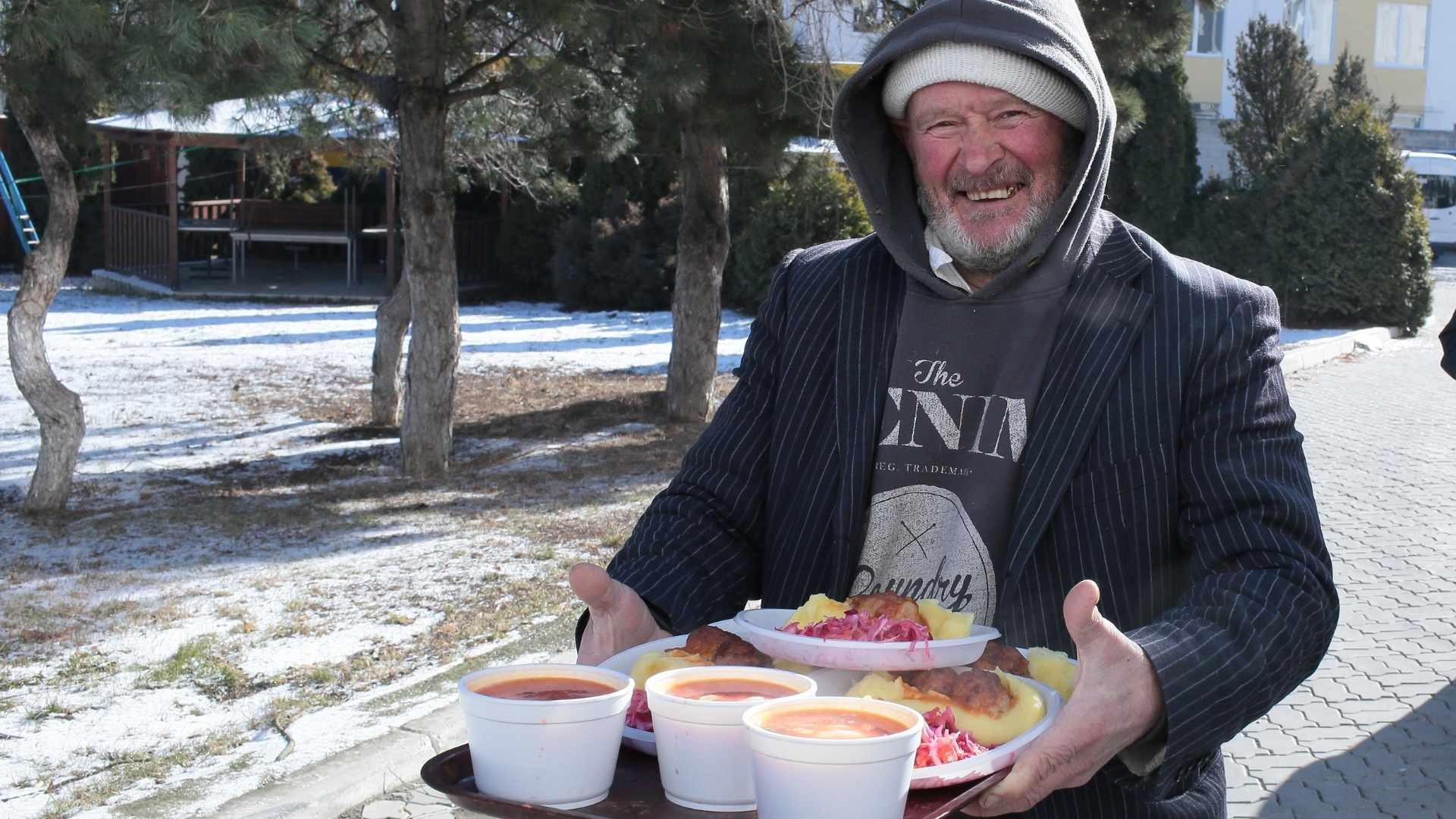 Homeless man with a tray of hot food
