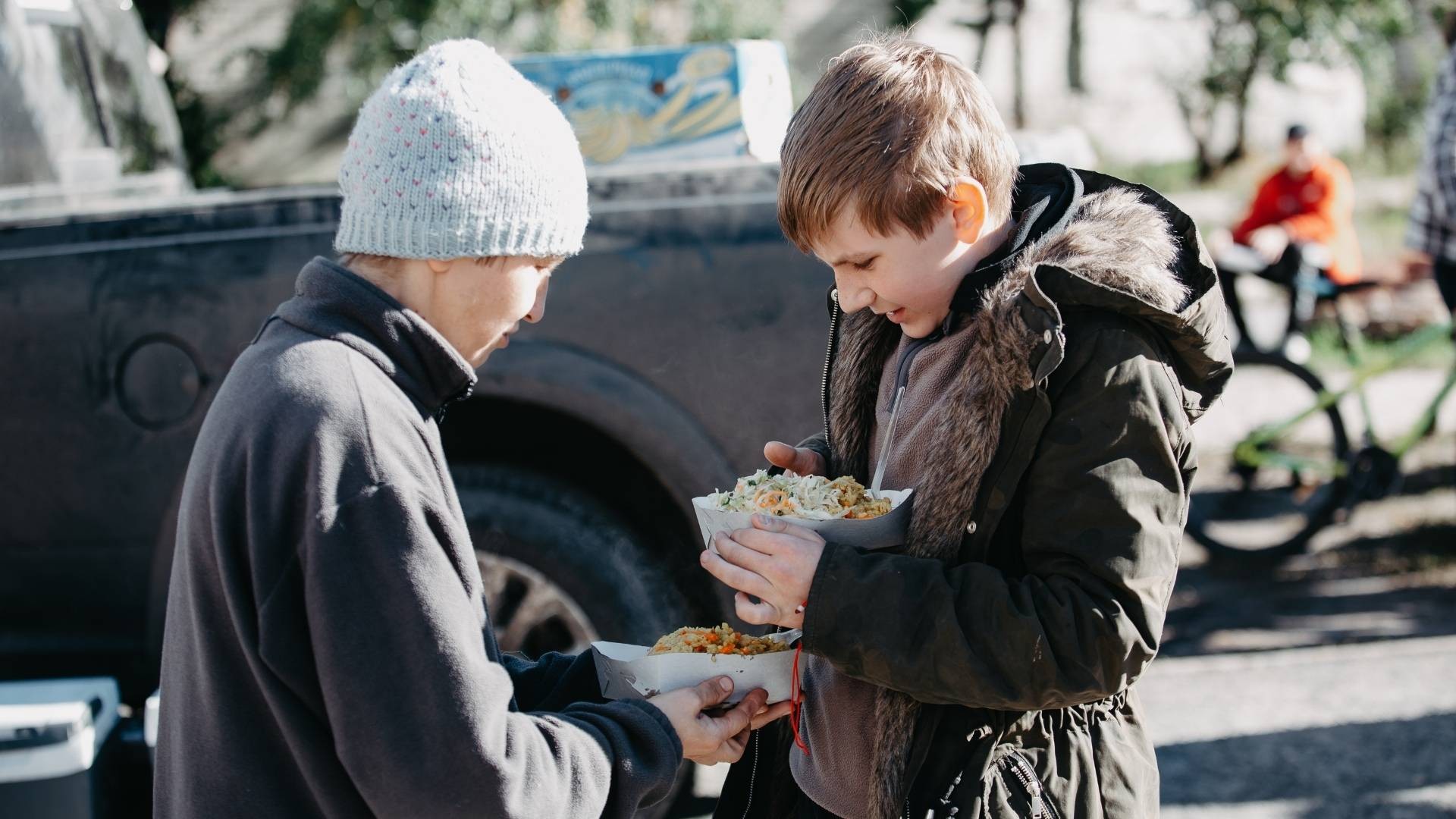 Two Ukraine boys eager to enjoy the hot meal they received.