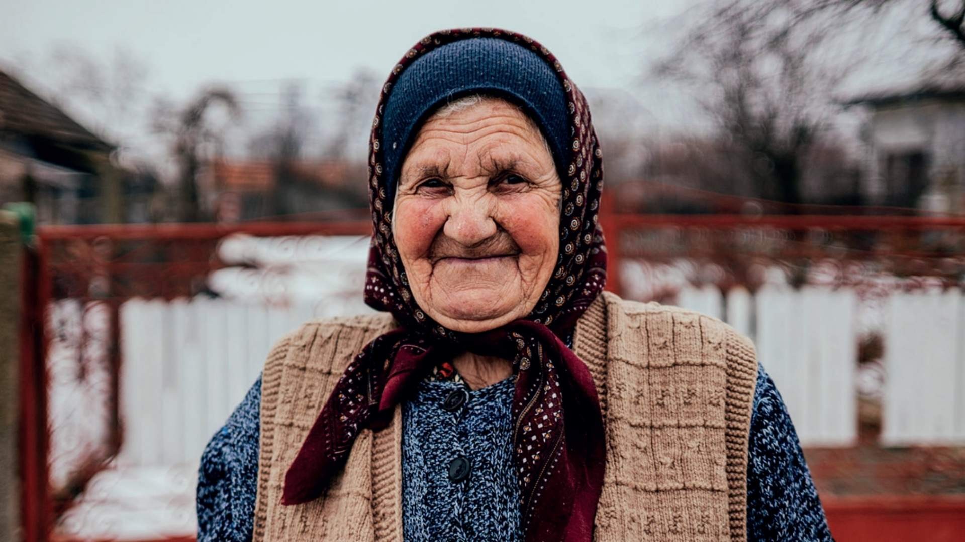 Elderly lady smiling with in winter clothes and head covering