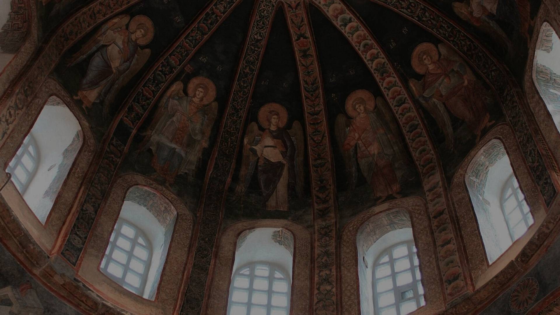 Light filters through glass block windows beneath a rounded painted church ceiling