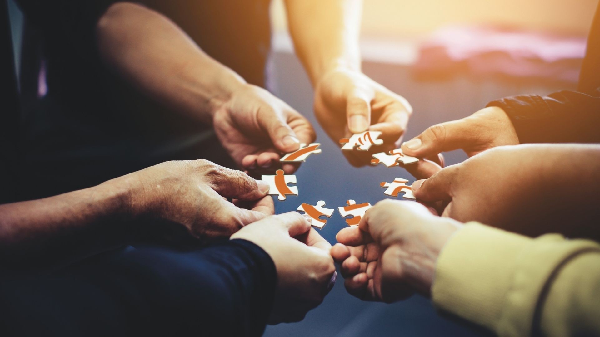 Hands each holding a puzzle piece