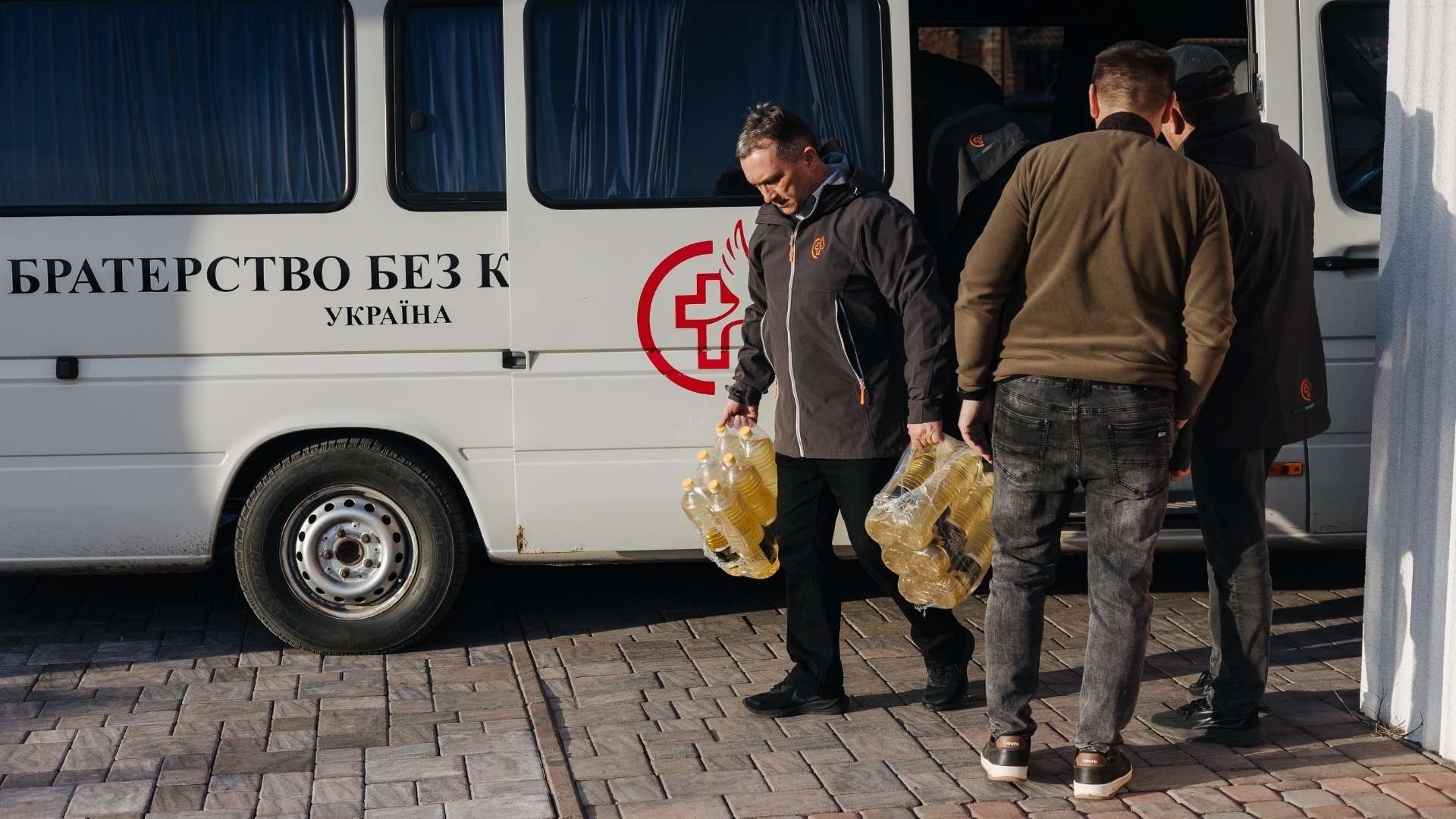 A man helping unload a van full of supplies