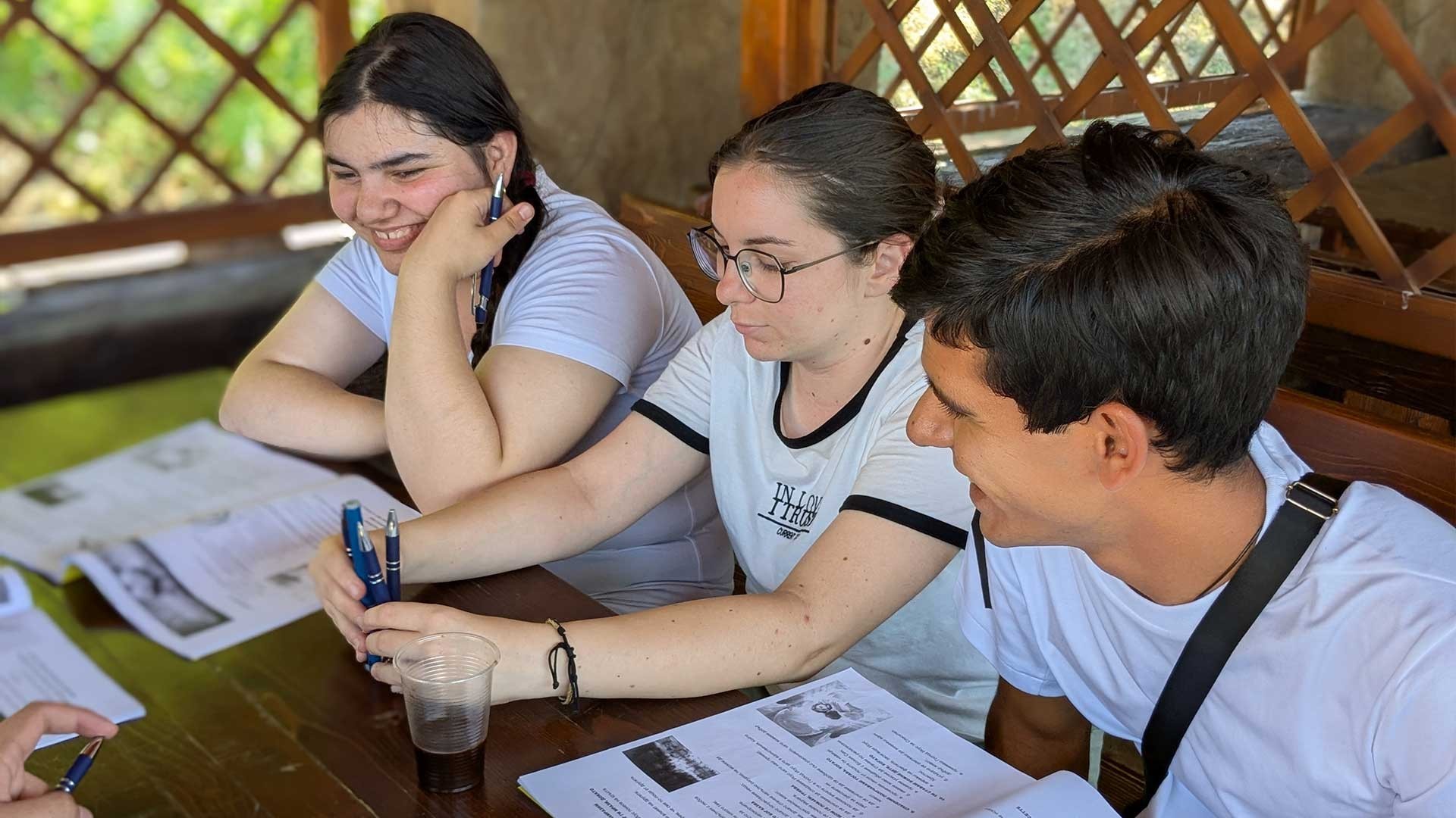 Young adults gathered around a table sharing a joyful moment