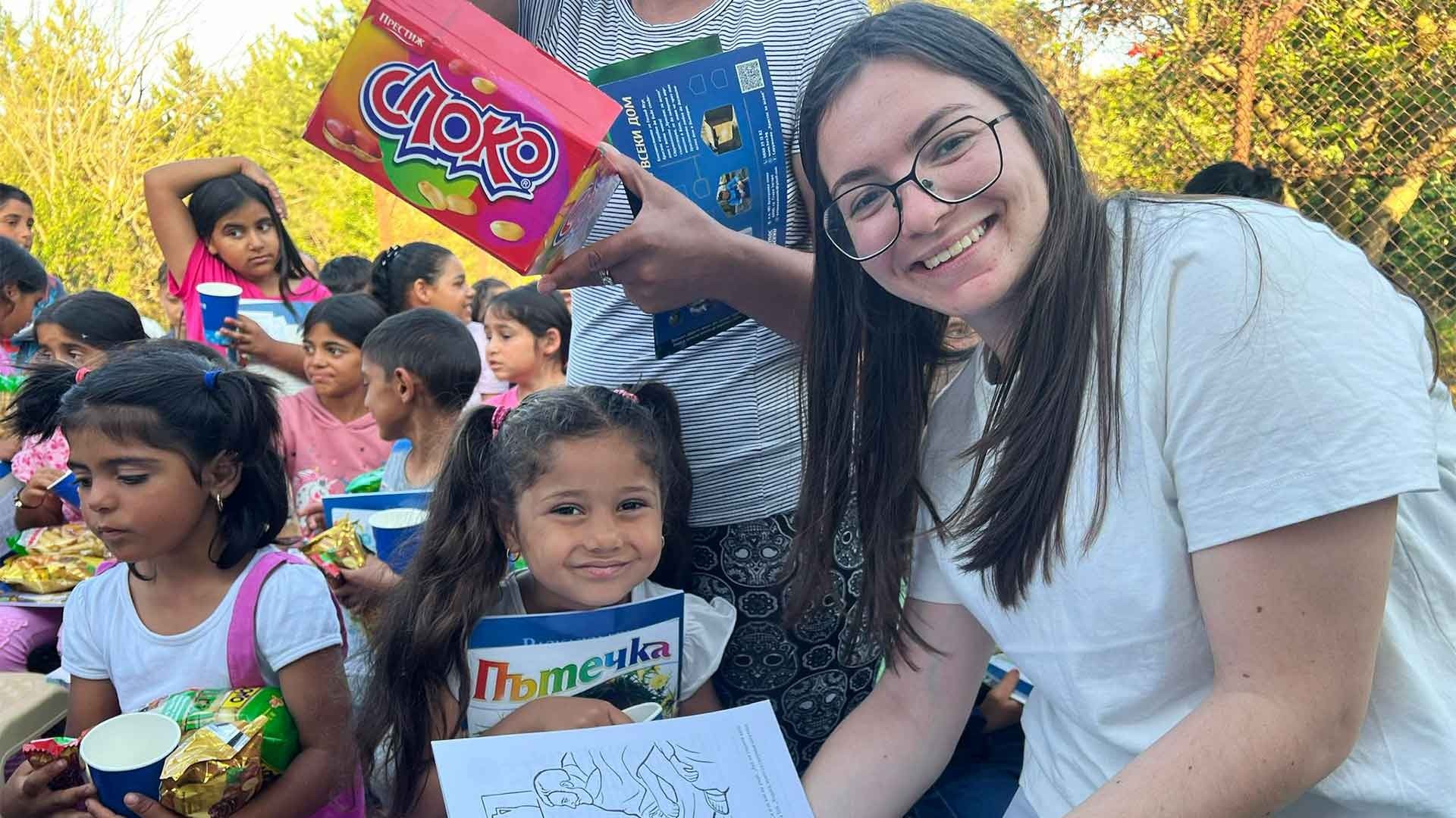 Young adult smiling warmly, sharing a joyful moment with children