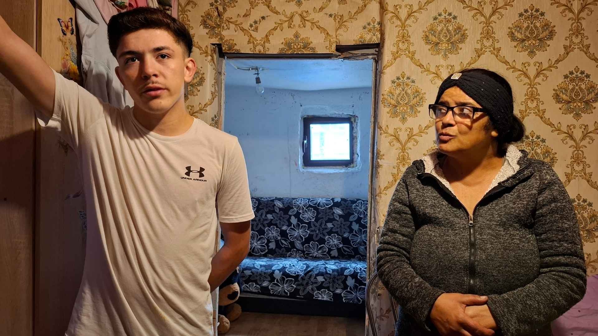 Teenage boy and his mother stands in a doorway talking