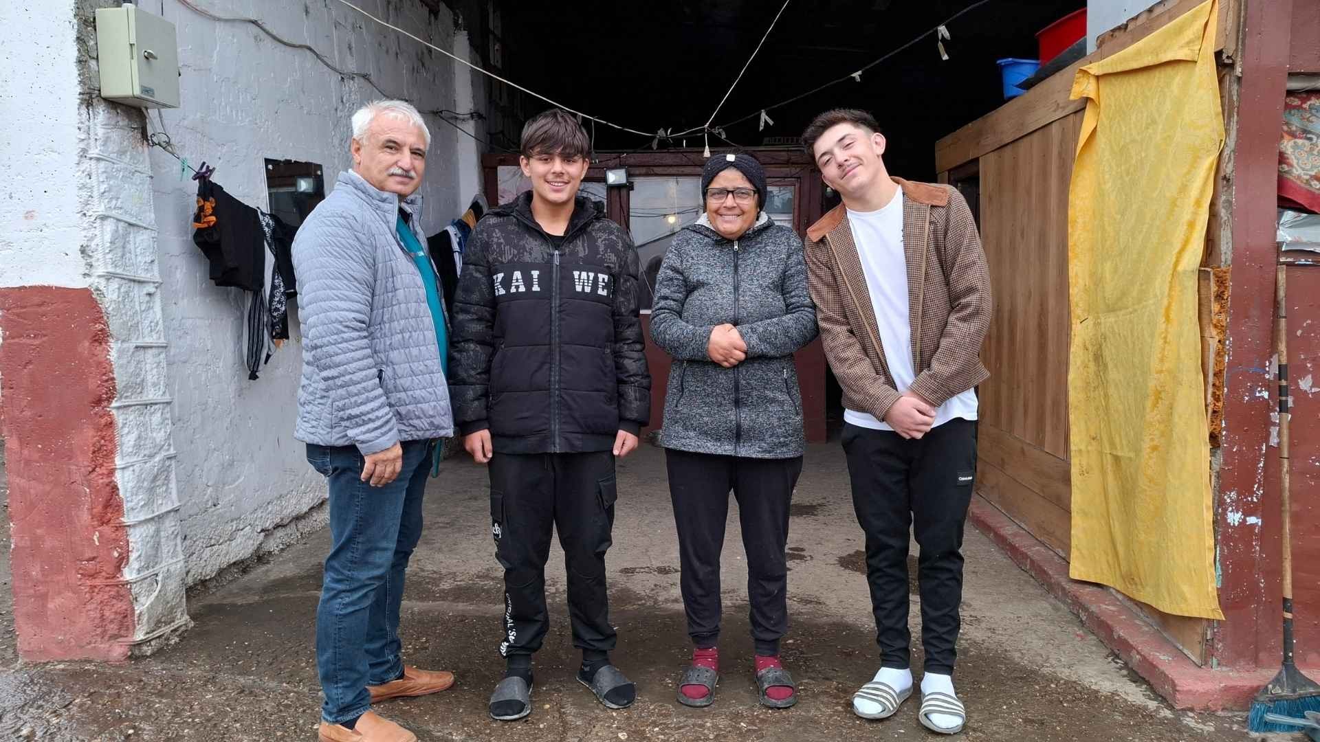 A gray-haired man shares a joyful moment with a smiling family