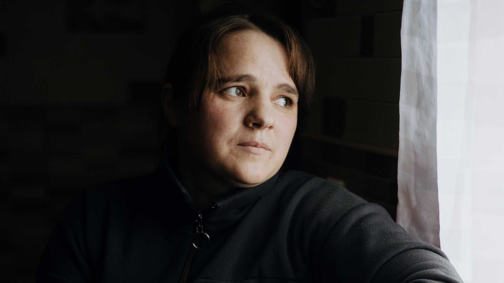 Iryna sits thoughtful, staring out the window