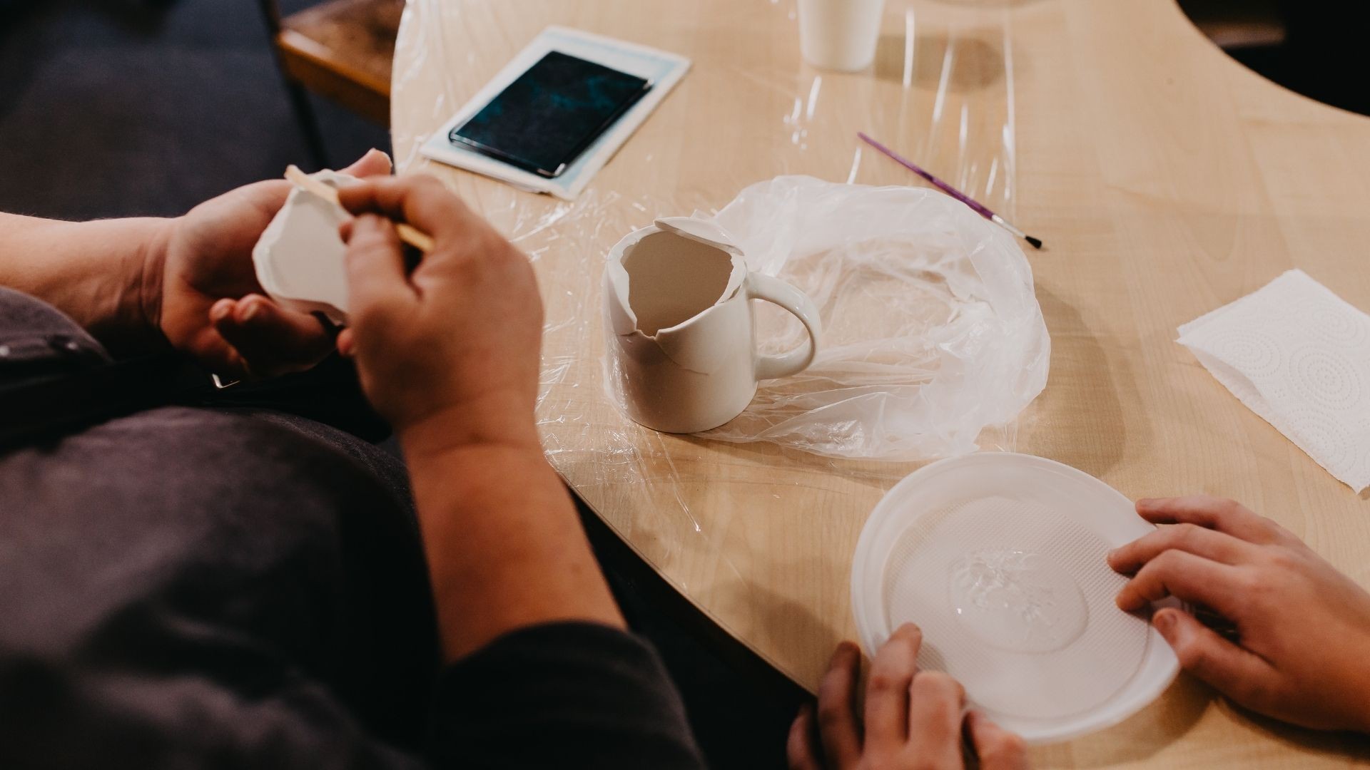 A broken ceramic cup being glued back together