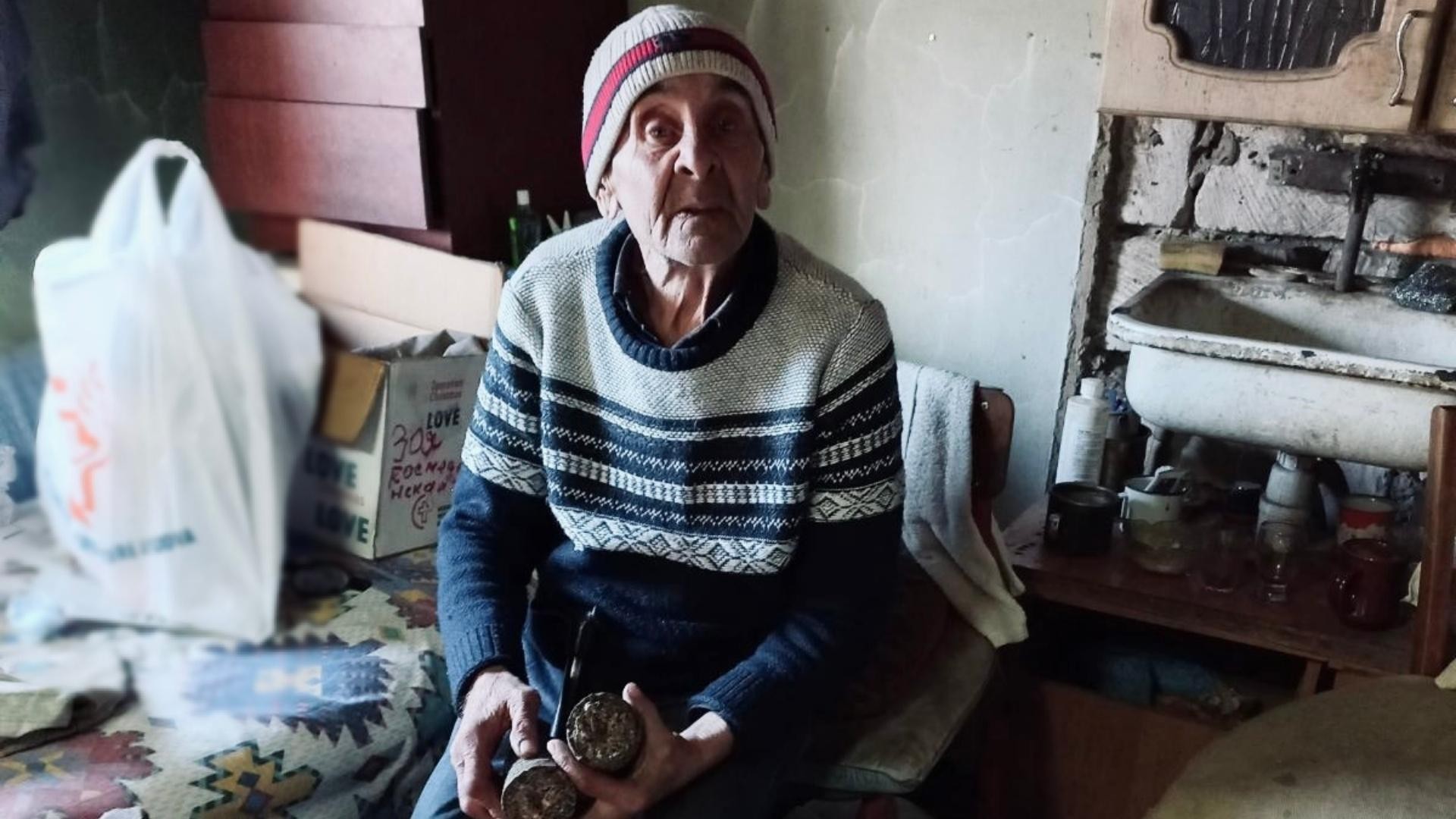 Elderly man sitting with his briquettes in his hands