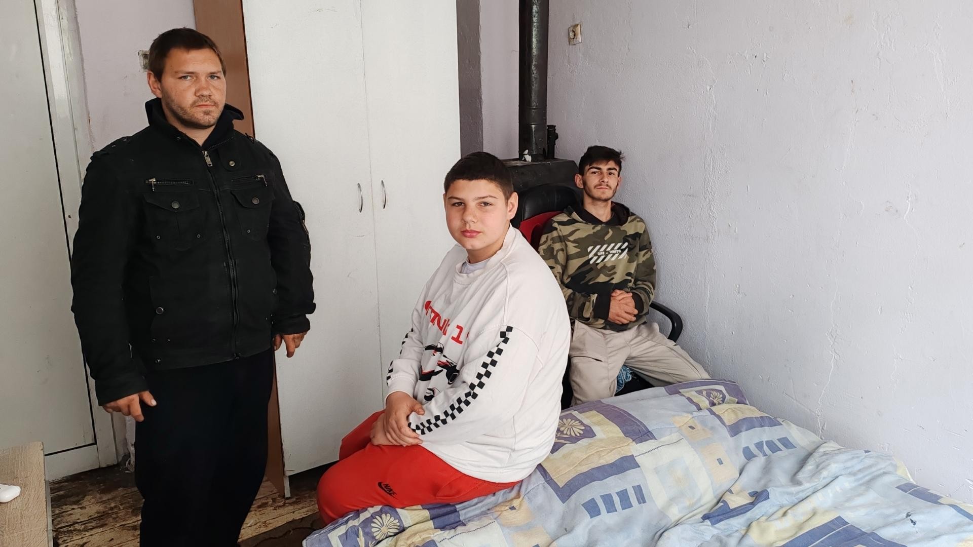 Three young adults spending time together in a bedroom.