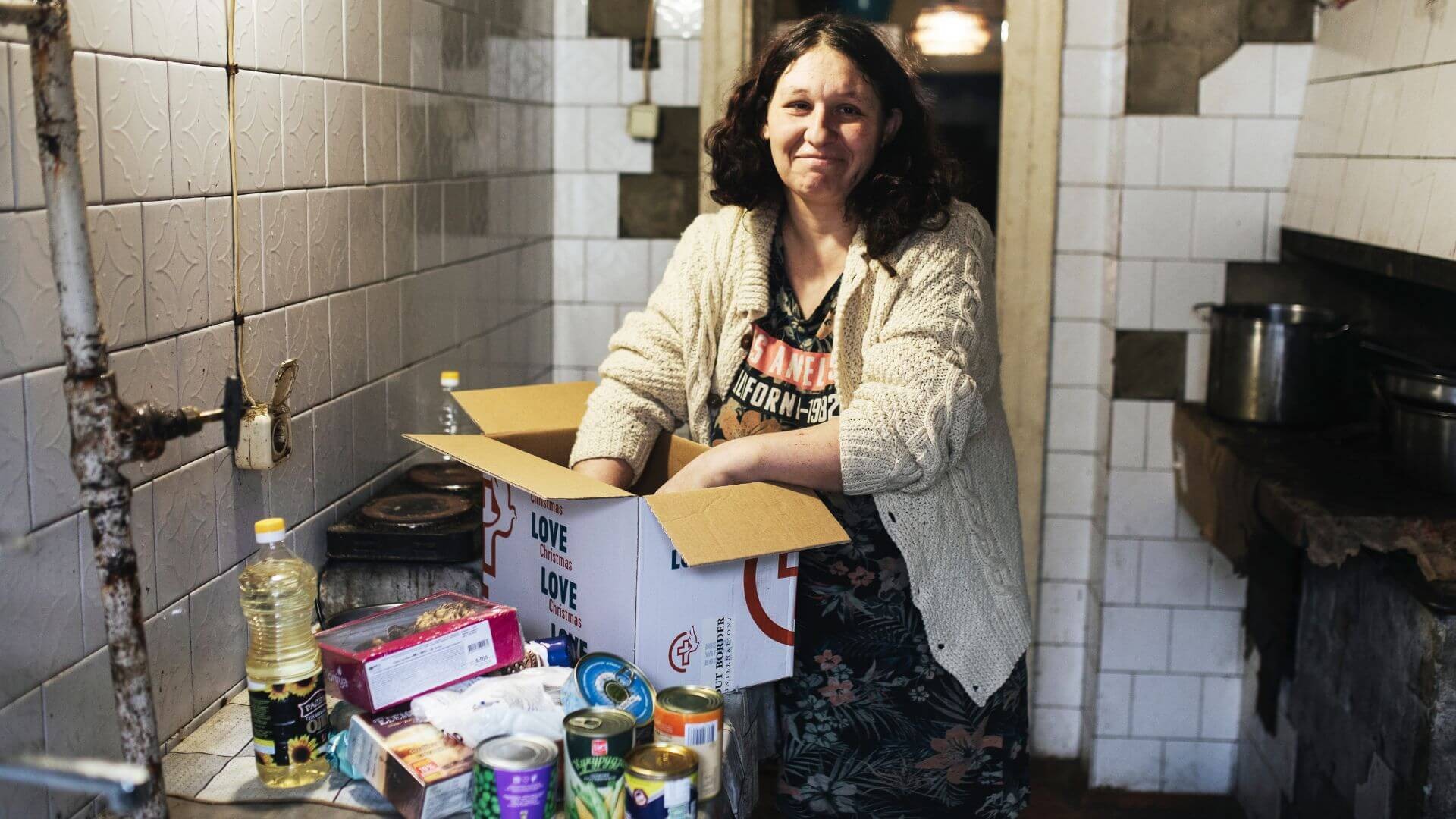 Woman in kitchen with unpacked food box