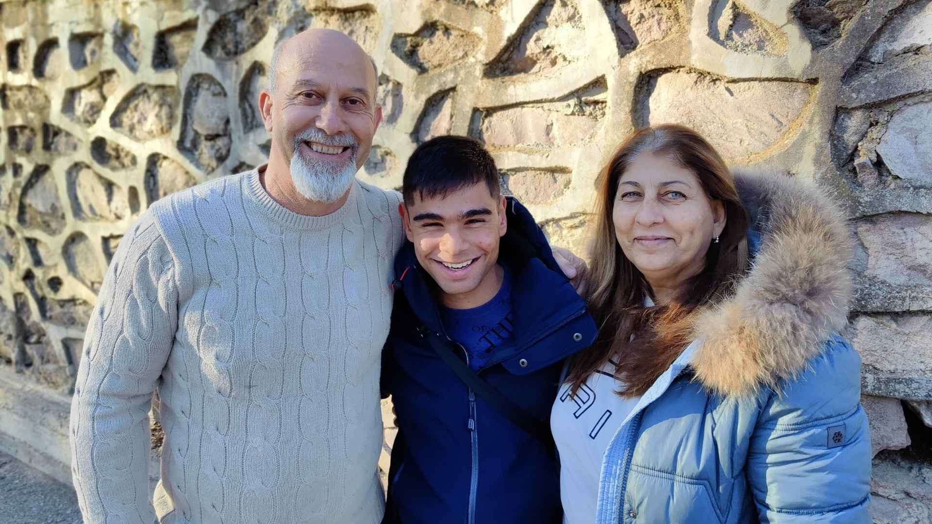 Three people standing in warm embrace