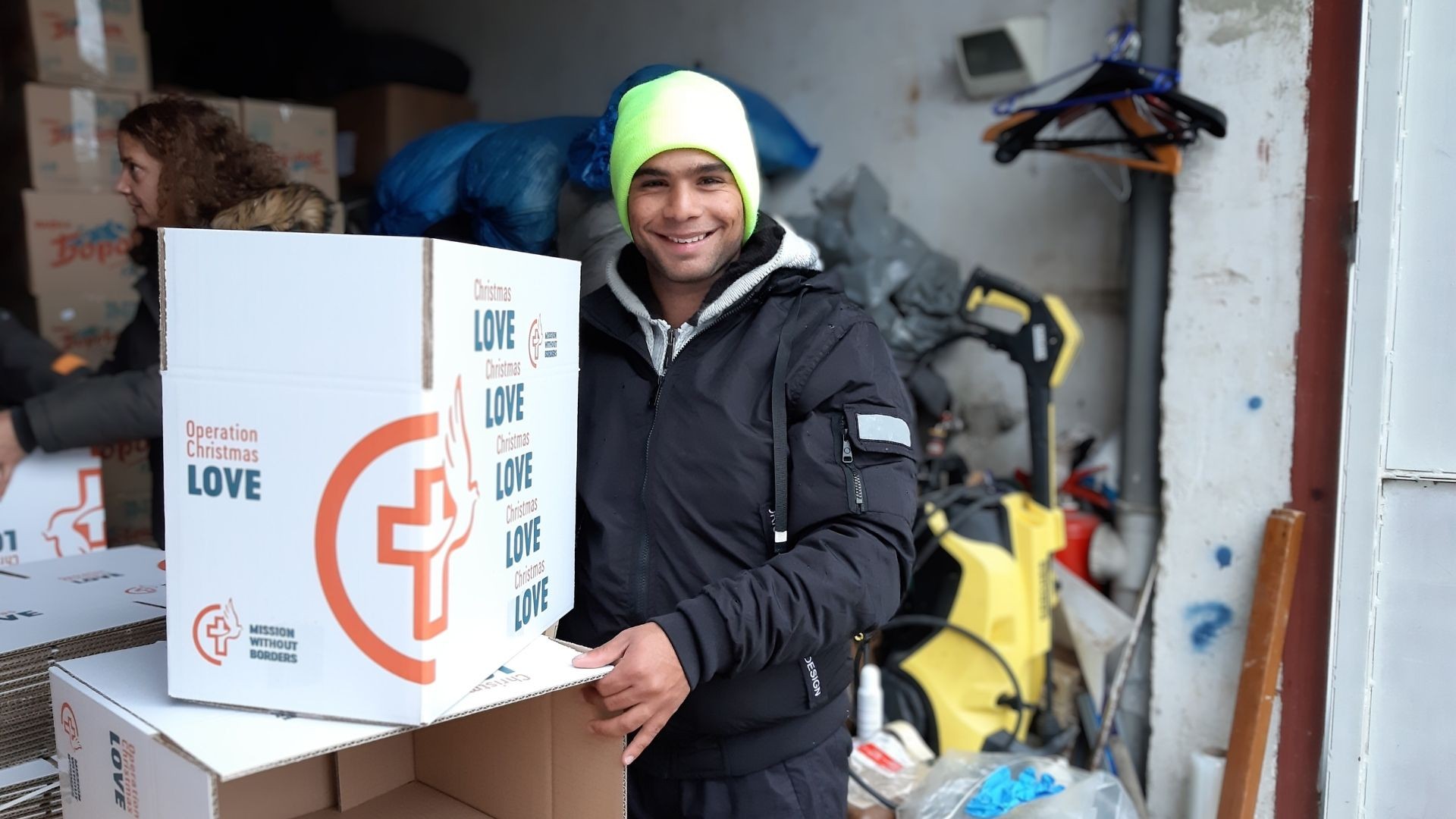 Young man standing behind empty boxes