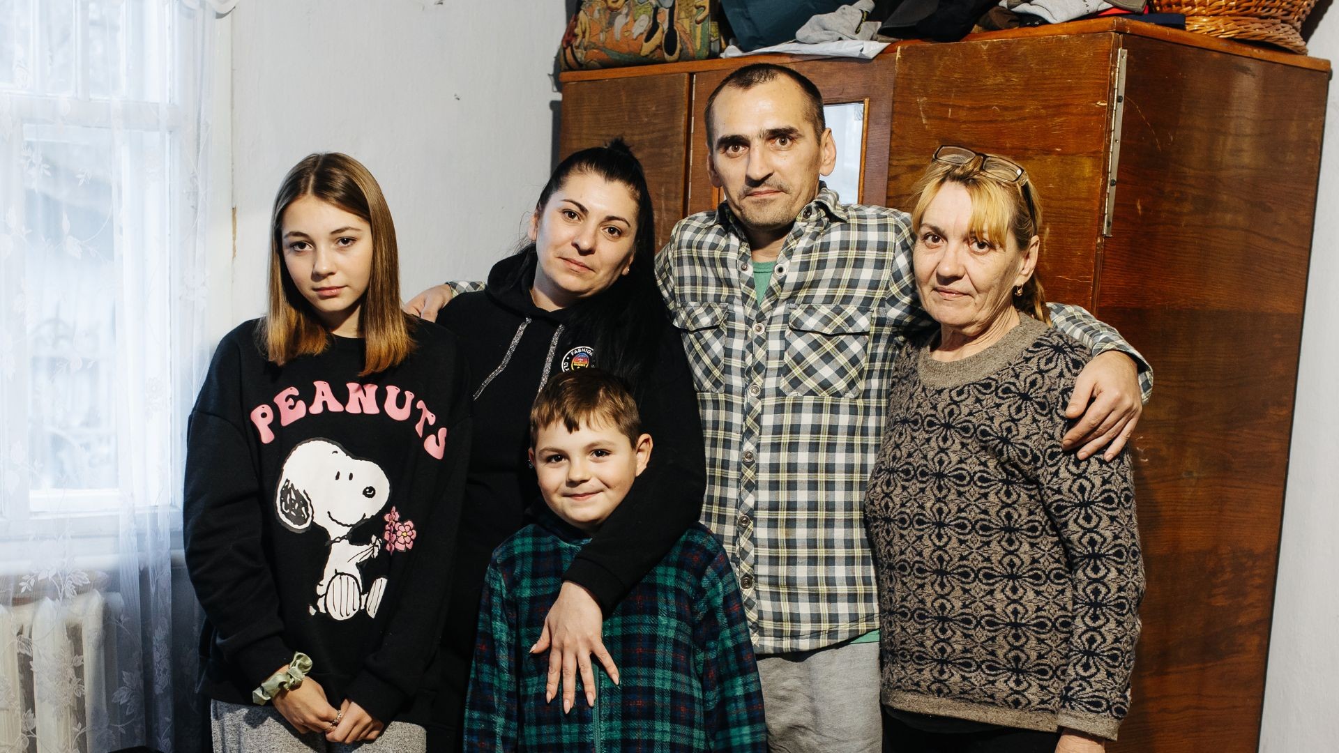 Family grouped together inside bedroom