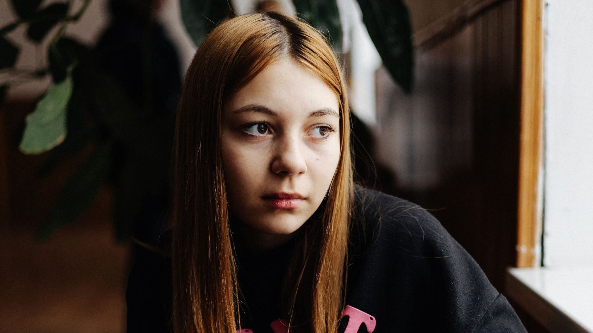 Teenage girl staring through the window