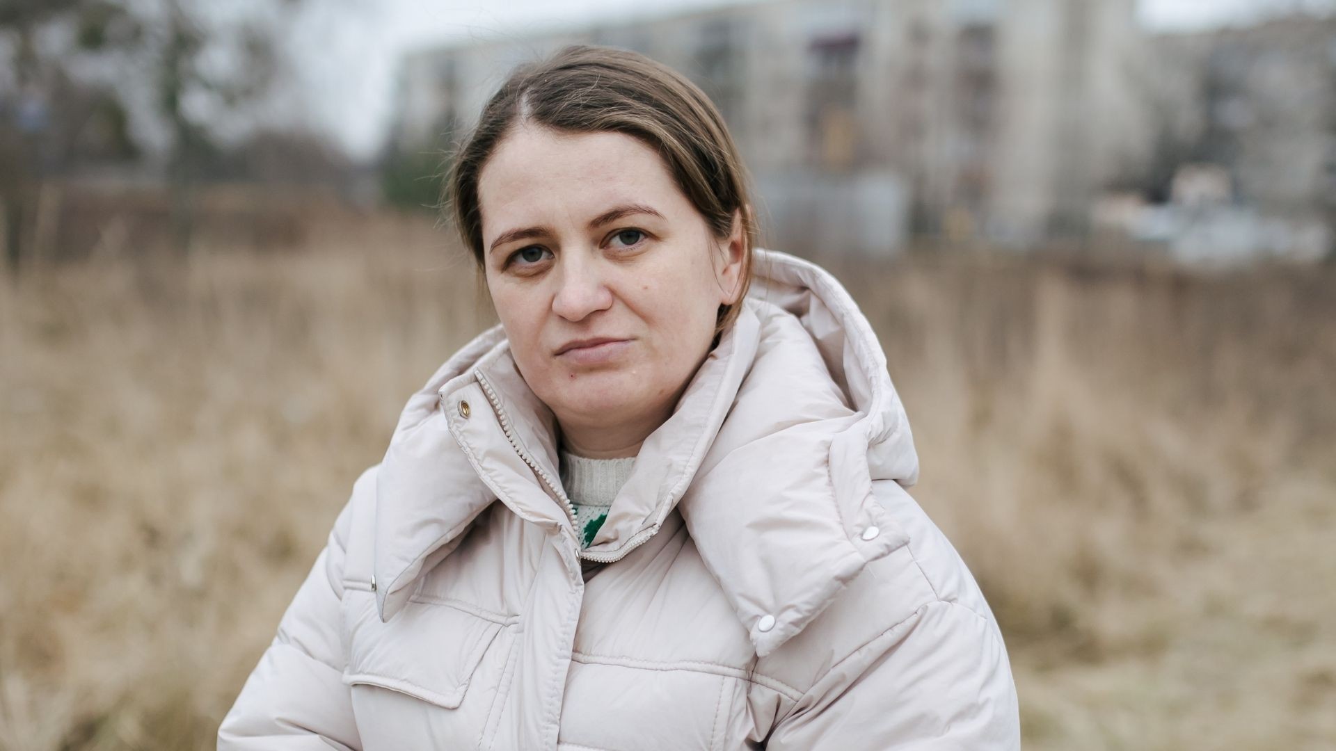 Woman standing in field dressed warmly